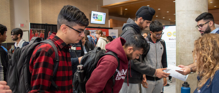 Students engaging with a booth at an event.