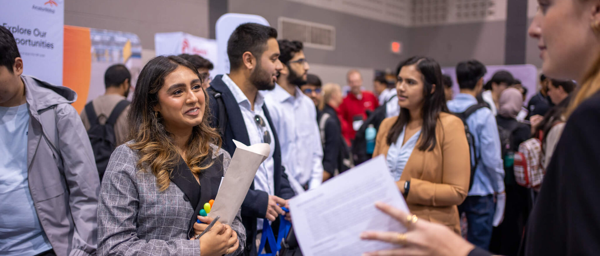 Student and recruiter connecting at busy career fair.